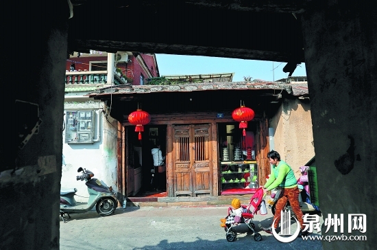 一位家长推着小孩走过连接西街的象峰巷