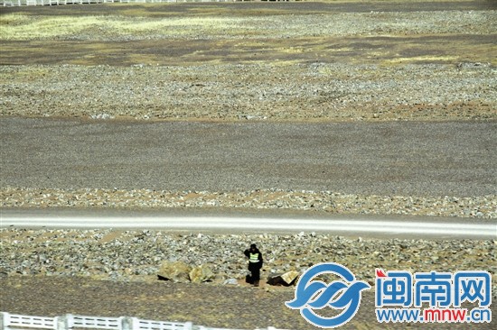 经过西藏那曲附近，一名路边向列车敬礼的道班员
