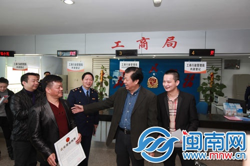 陈荣洲（右二）给企业法定代表人颁发新版营业执照