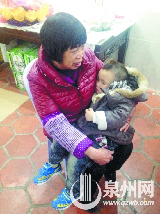 小男孩在吴阿婆怀里安静地睡着