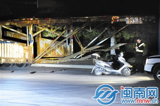 民警将电动车从挂车底拉出来