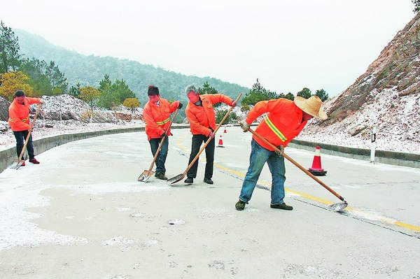 工人在清除路面结冰