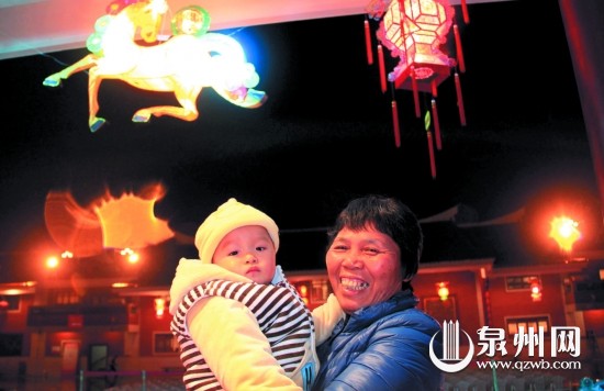 高奶奶抱着十个月大的孙子前来赏灯
