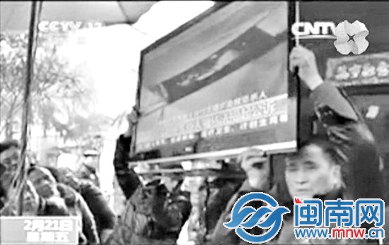 村民将电视机搬到大门口让大家看央视报道