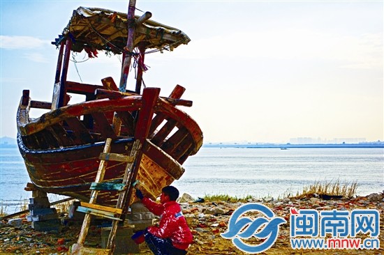 一位师傅正在对船涂油漆