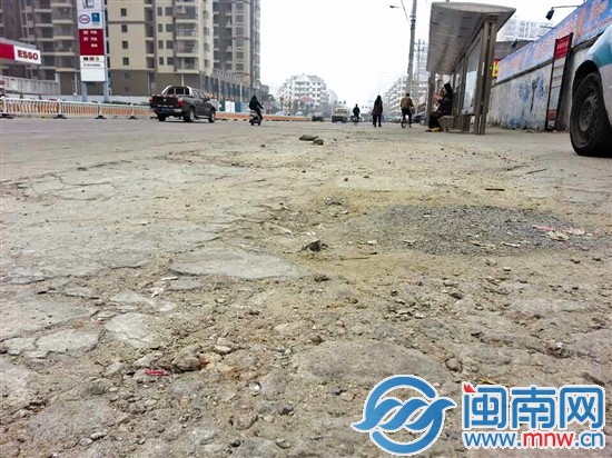丹霞路加油站对面的公交站台，路面多处破损
