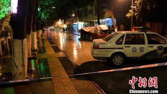 图为警方正在对案发路段进行封锁调查