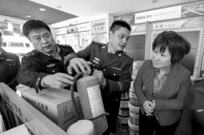 消防人员正在检查一商铺内的消防器材