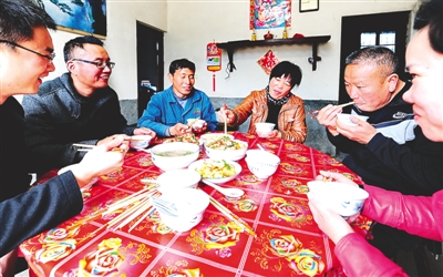 付好“餐票”后在屯上村村民何清家里吃午饭