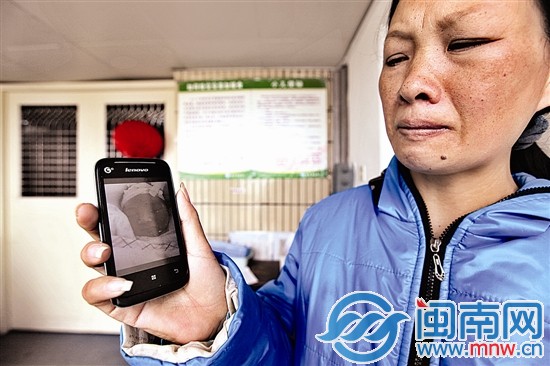 汤冬英给我们看孩子照片，说着孩子的遭遇，忍不住哭泣