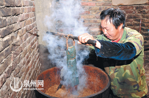 茶籽磨成粉后倒入木桶蒸煮，中间放入用编织袋包裹的 