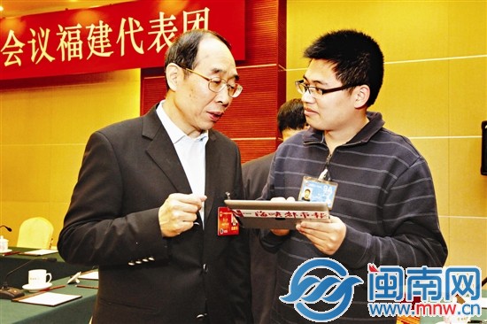 尤权书记通过本报特派记者手中的iPad，浏览读者、网 