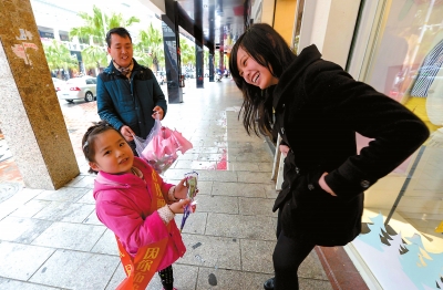 赵蓝灵小朋友给街上的女士送上玫瑰花