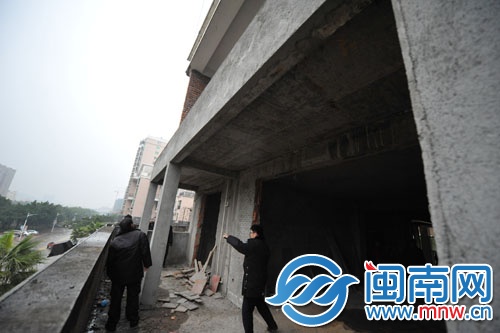 业主在阳台上违建，执法人员正在调查