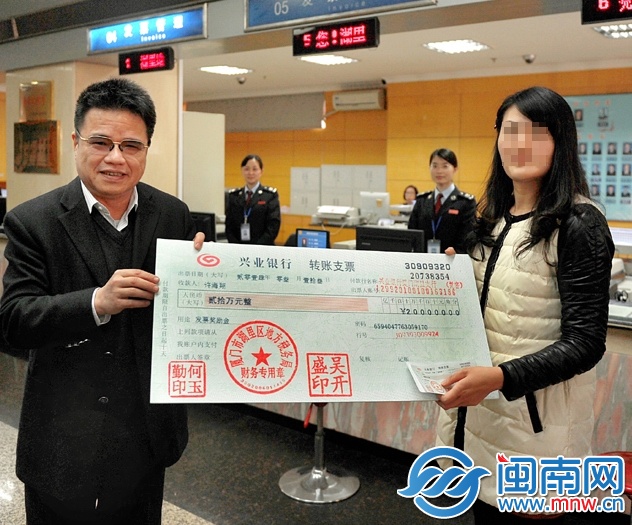 许女士从厦门市地税局局长吴振坤手中接过20万元的“ 