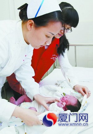 医院志愿者和护士为宝宝更换尿布