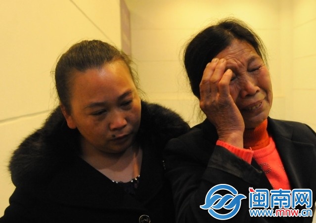 宝宝的奶奶（右）一出机场，看到接机的儿子掩面哭泣
