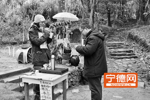 傅喜文在给过往游客免费品茶