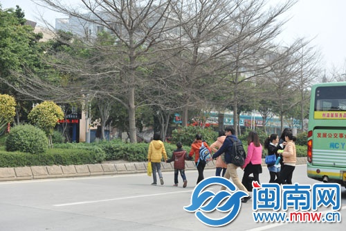 通港西街有家长带着孩子一起横穿马路