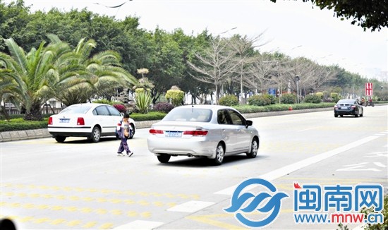 丰泽第四中心小学附近，一名小学生低头横穿马路