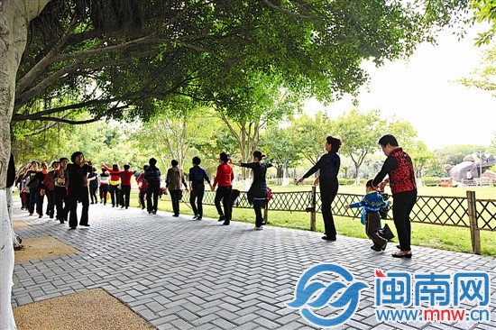 一名孩子跟在后面也一起跳着