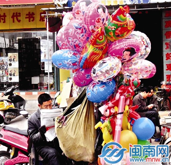 一名小贩闹中取静看报纸