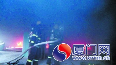 消防人员在扑灭仓库的火。