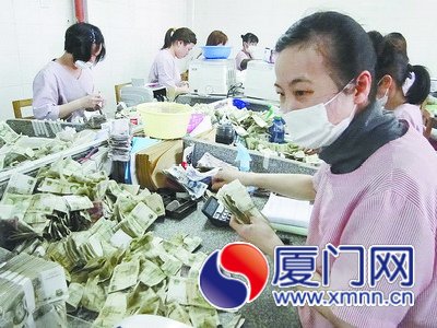 点钞工邱丽珊（右）干起活来一丝不苟。