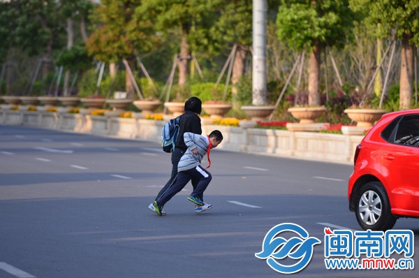 刺桐路东涂街口，一家长带着孩子飞奔横穿马路