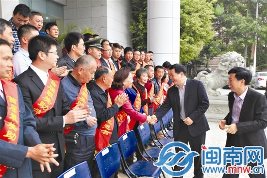 泉州市委常委、组织部长陈沈阳和志愿者们握手