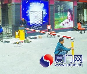 工人在酒店门前安装停车场道闸。