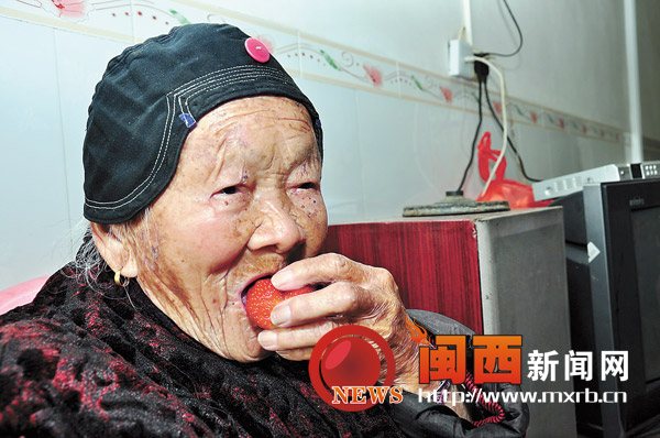 108岁的老人兰安兰在吃着草莓。