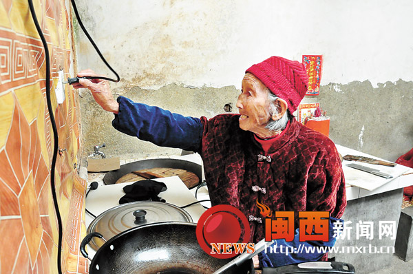 104岁的李妹老人准备用电磁炉做饭