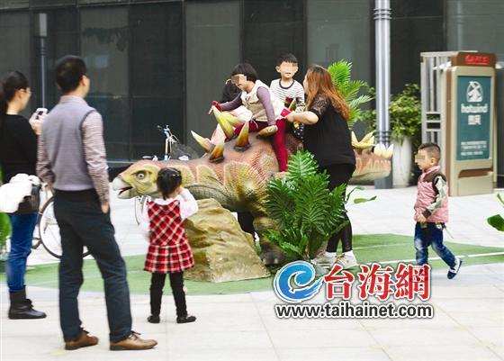 不少小孩爬到“恐龙”背上