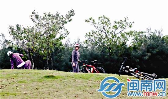 两位女生骑自行车，从华侨大学到泉州市区滨海公园踏青
