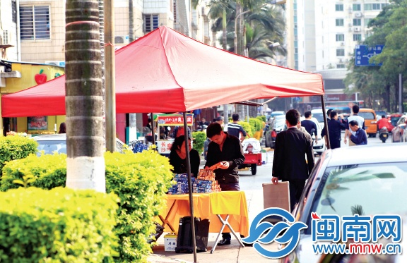 一个卖牙膏的小贩依旧用音响揽客，只是把音响藏在桌 