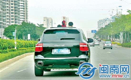 车上三个小孩子将脑袋伸出天窗外摇头晃脑