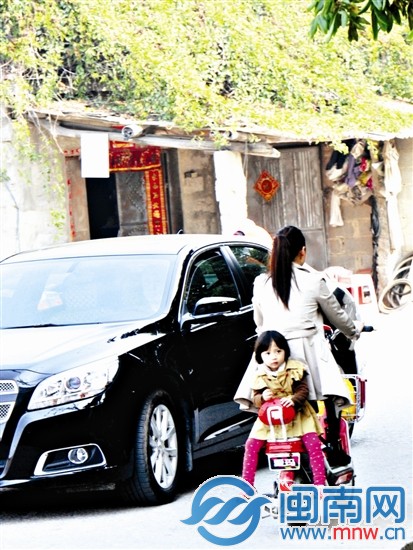 女童反身坐在电动车后座