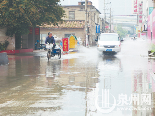 9日下午，雨后两天，沉洲路仍积满水，小车经过溅起 