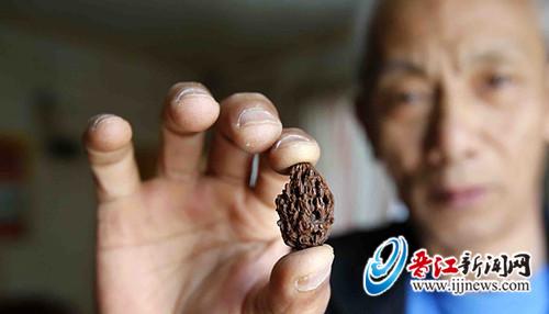 2.8厘米的桃核上刻有31尊头像
