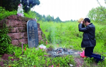 今年清明节，王本余在祖坟前拜祭父母
