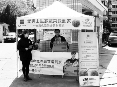 武夷一方田工作人员在一小区门口摆台推广生态蔬菜