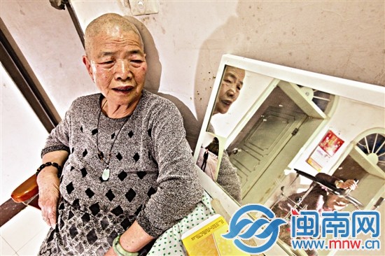 帮女儿换完尿布的光头妈妈坐在凳子上