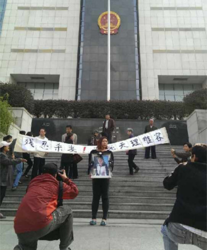 妻子家人在法院门口拉横幅鸣冤。