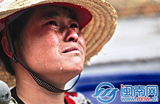 工人陶女士看着火场，留下了两行眼泪