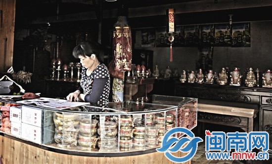 她一边看着报纸一边等着生意的到来