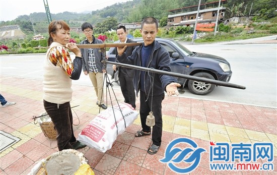 颜秋宁和妻子林美丽正在称黄瓜