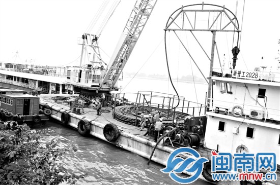 鼓浪屿新建两回海底电缆，施工人员正把电缆慢慢放入 