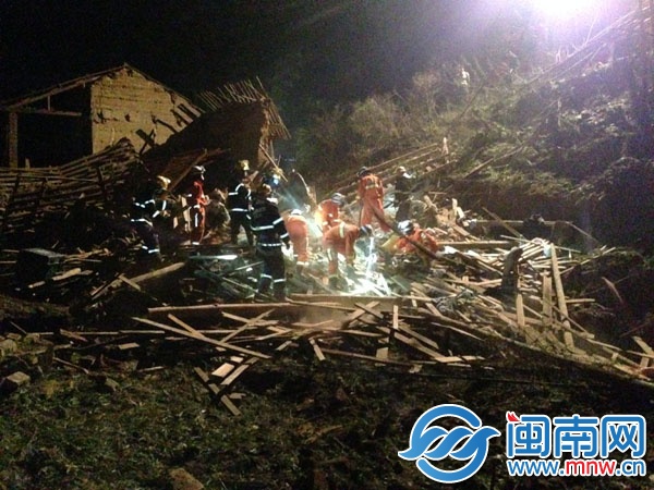 两层民房坍塌后，消防官兵在现场挖开梁木泥土，救出 