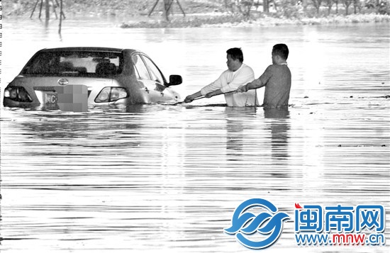 小车困住了，两男子想把车拉出
